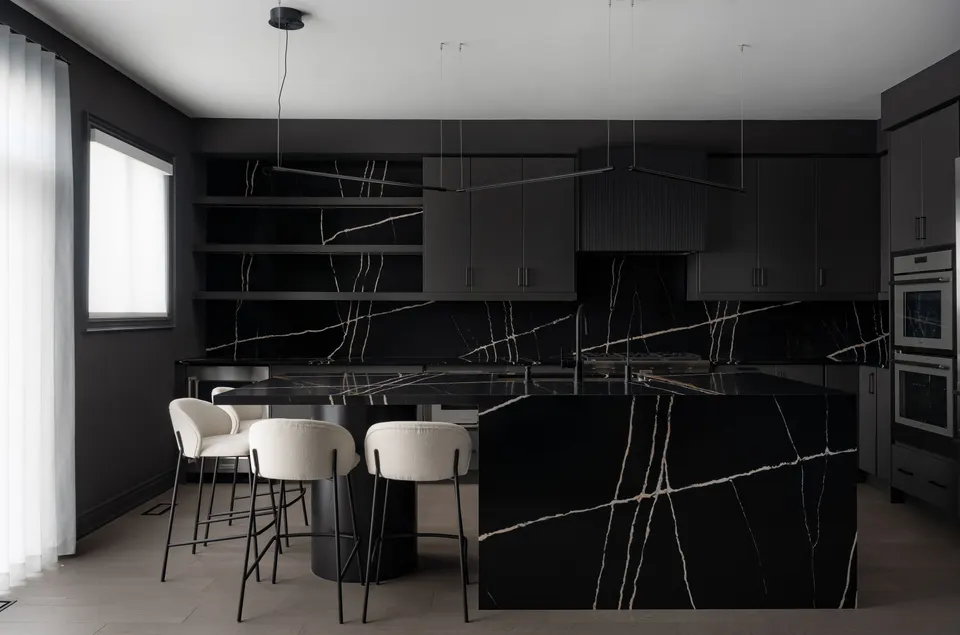 Charcoal kitchen with a black marble island and backsplash veined in white and gold, open shelving and cream bar stools