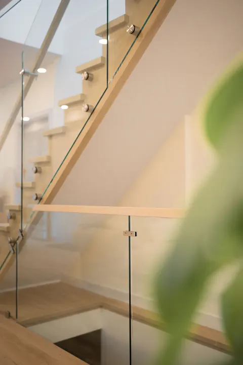 Oak stair with a frameless glass railing inside the addition