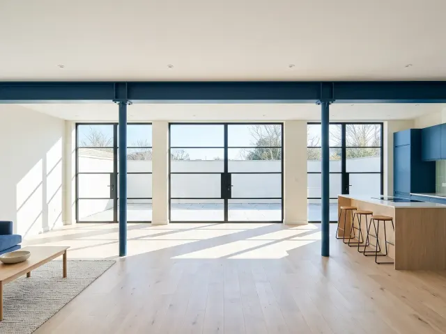 Open-plan living and kitchen with a long steel beam where a bearing wall stood